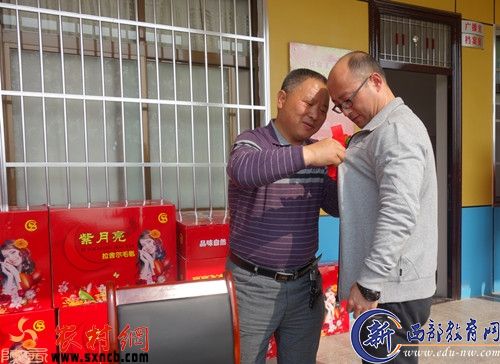 红花戴给基层工作建设的功臣。西渠头村支部书记吕新发为第一书记佩戴光荣花。.