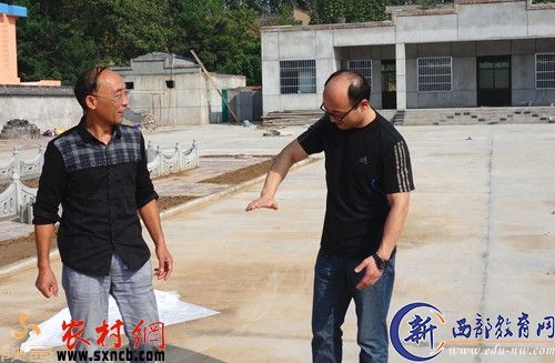 第一书记宋雪源和村主任杨社民在村部建设工地上。