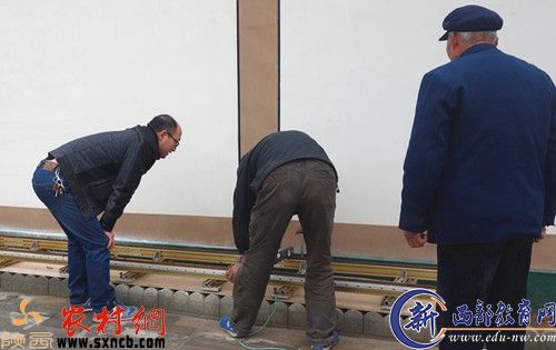 正在建设中的文化墙，宋雪源与建筑工人在一起。