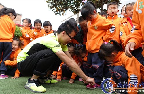 有孩子鞋带开了，李宏基蹲下来帮助孩子把鞋带系上。