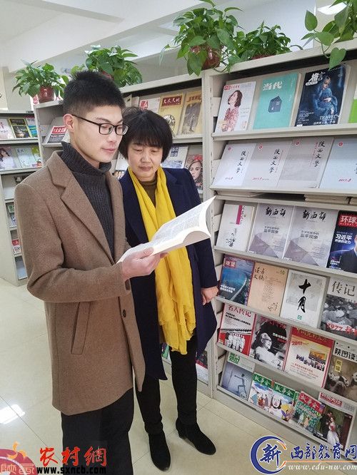 馆长张丽萍（右）和读者田航在翻阅杂志。
